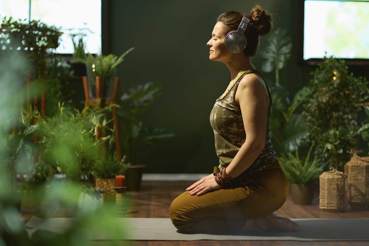 relaxed stylish 40 years old woman at green home doing yoga