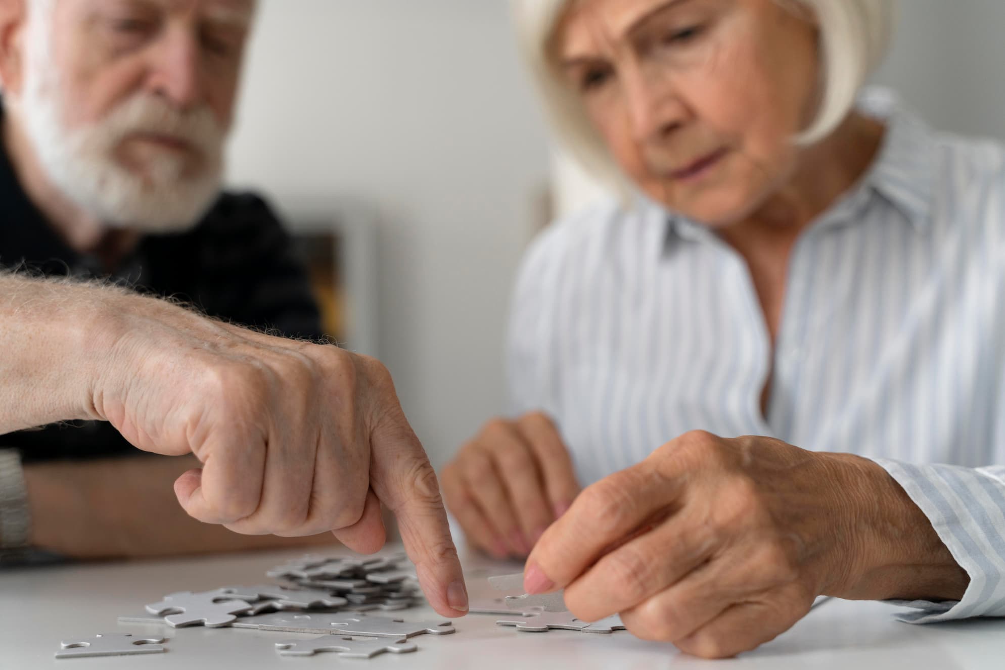 Couple de seniors faisant un puzzle illustrant la memoire-transgenerationnelle et la stimulation cognitive